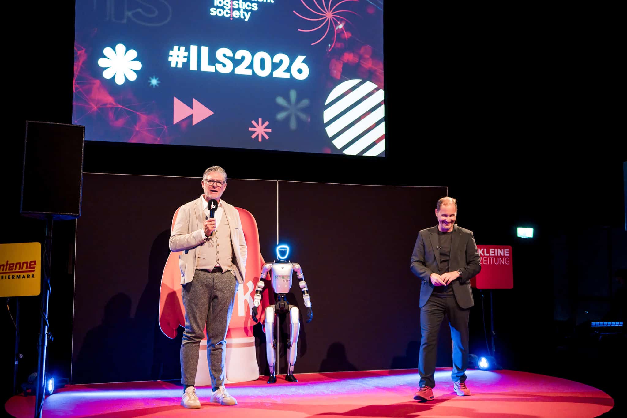Jürgen Menhart mit einem humanoiden Roboter auf der Bühne beim ILS365